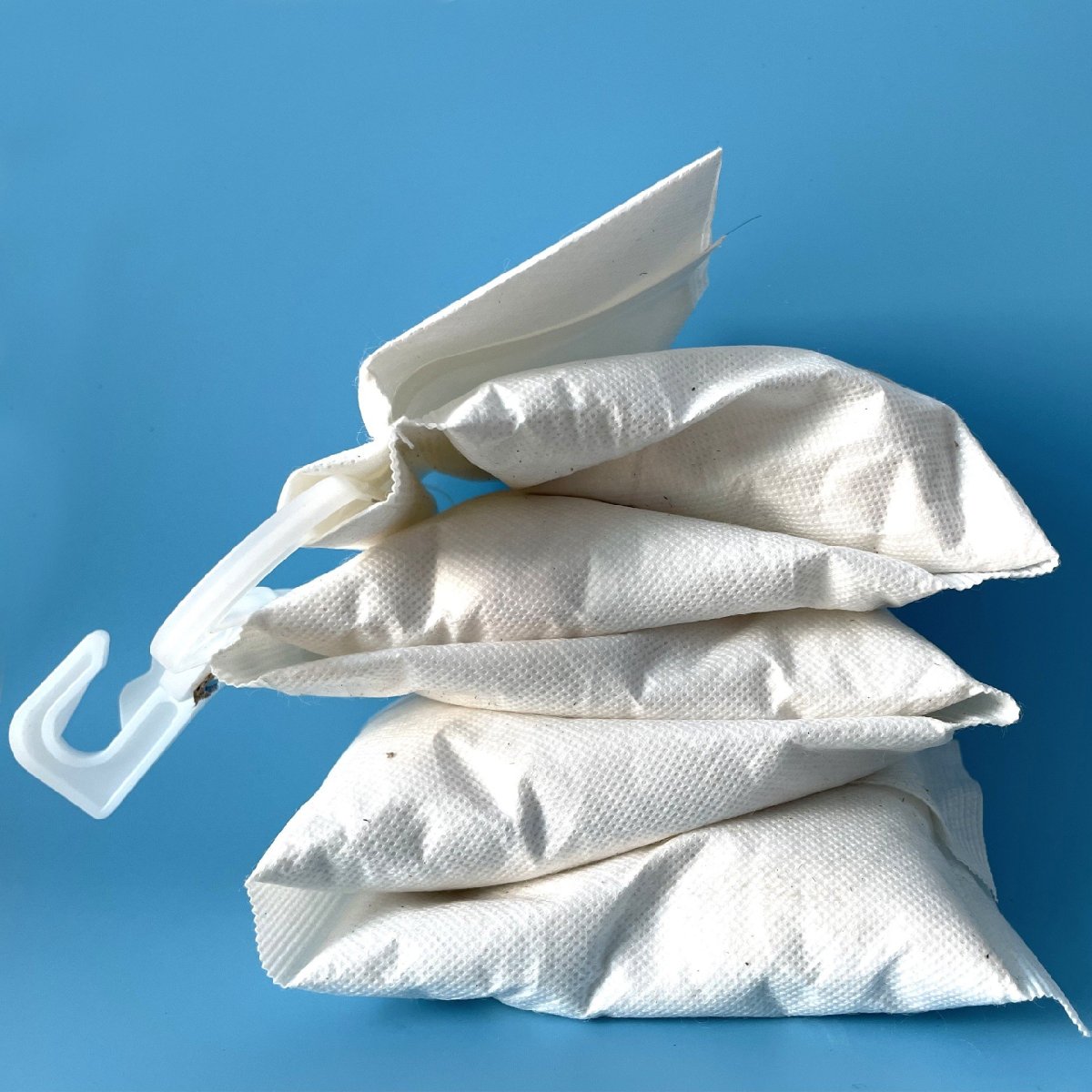 Stacked hanging desiccant pouches used to absorb container moisture